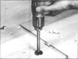 4. Utilice una broca Forstner o de espuela múltiple en un taladro motriz portátil para de esa forma poder perforar todas las mortajas de poca profundidad que sujetan la vara de este ropero