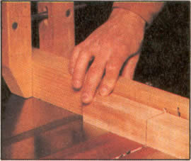 5. Alrededor de las piezas para las patas haga un corte de 4,8 mm (3/16") de profundidad, para que la madera no se astille al tornearla. Extienda el cartabón de ingletes con una pieza sobrante.
