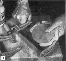 Fig. 8 -Al encolar la taracea en los bordes de la tapa, se emplean trozos de madera para apoyar la prensa