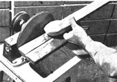 Una lijadora de disco es la más adecuada herramienta para redondear el extremo esférico del brazo. Use para eso un bloque de soporte