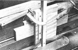 Esta guía para espigas, construida de piezas sobrantes, se mueve sobre la guia de cortes longitudinales de la sierra de banco y mantiene el trabajo en la posición vertical específicamente para cortar una ranura en su extremo