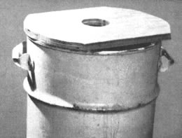 El banco de trabajo es un barril con un lastre de doce ladrillos y un pedazo de madera con agujero en el centro para darle cabida al mango de la herramienta