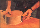 1 Una vez que haya cortado el molde de madera terciada en forma ovalada, utilice un bloque lijador envuelto en papel lija de grano 80 para que le proporcione una terminación bien pulida.