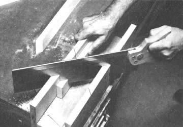 Una caja de ingletes permite guiar un serrucho de lomo de dientes finos para hacer cortes rectos de 90° y de inglete de 45°. El serrucho se desliza en ranuras de guía cortadas en los lados de la caja. Sujete bien el trabajo