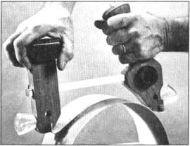 El poste delantero y el mango trasero de la lijadora de contornos se deslizan sobre un riel de acero para ajustarse a los trabajos pequeños (arriba) y a los de un diámetro mayor (abajo)